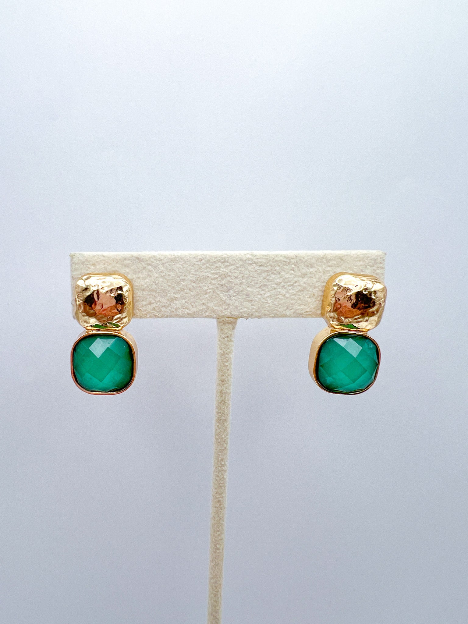 a pair of earrings on a stand