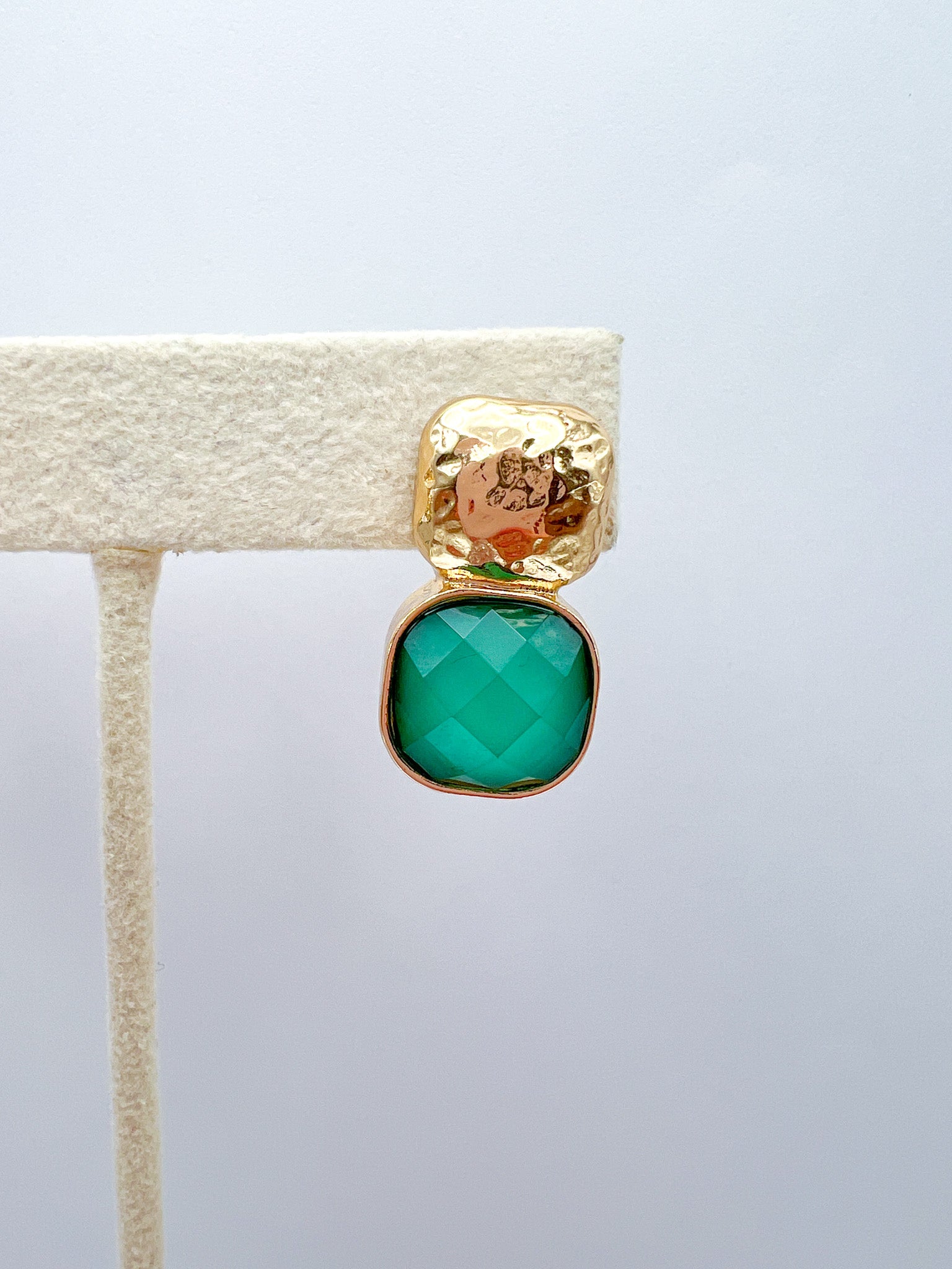 a gold and green earring