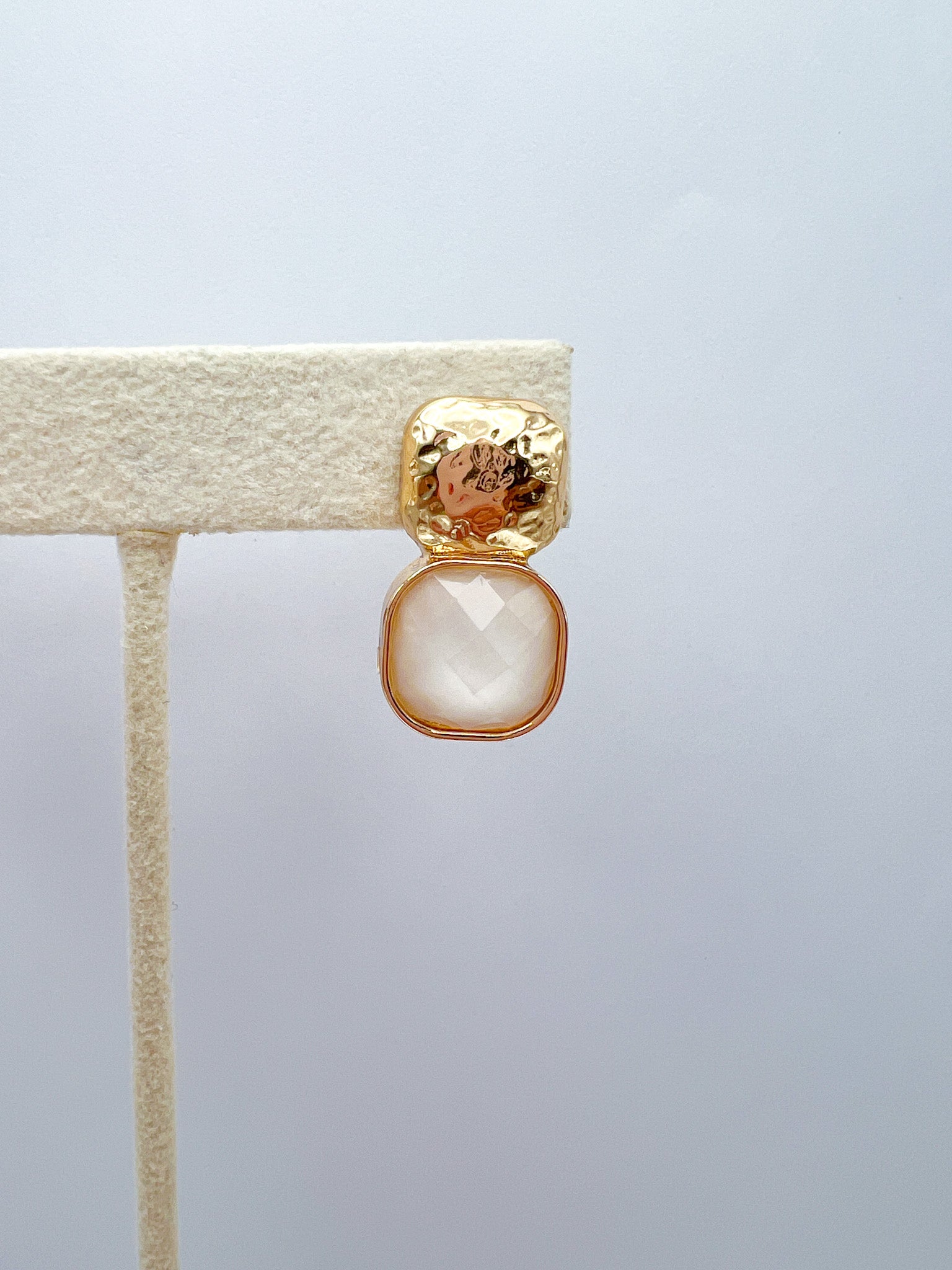a gold and white earring