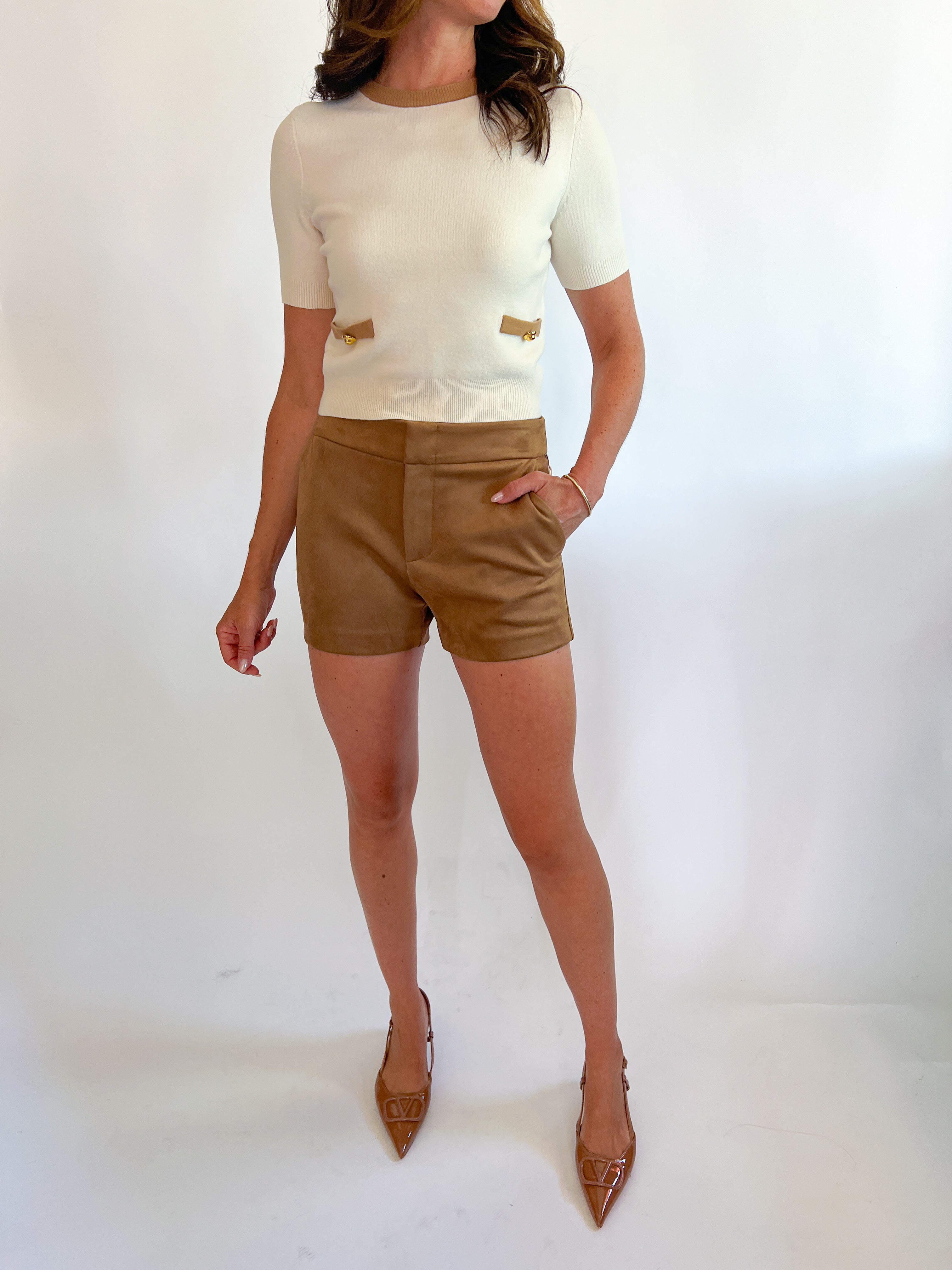 a woman wearing a white shirt and brown shorts