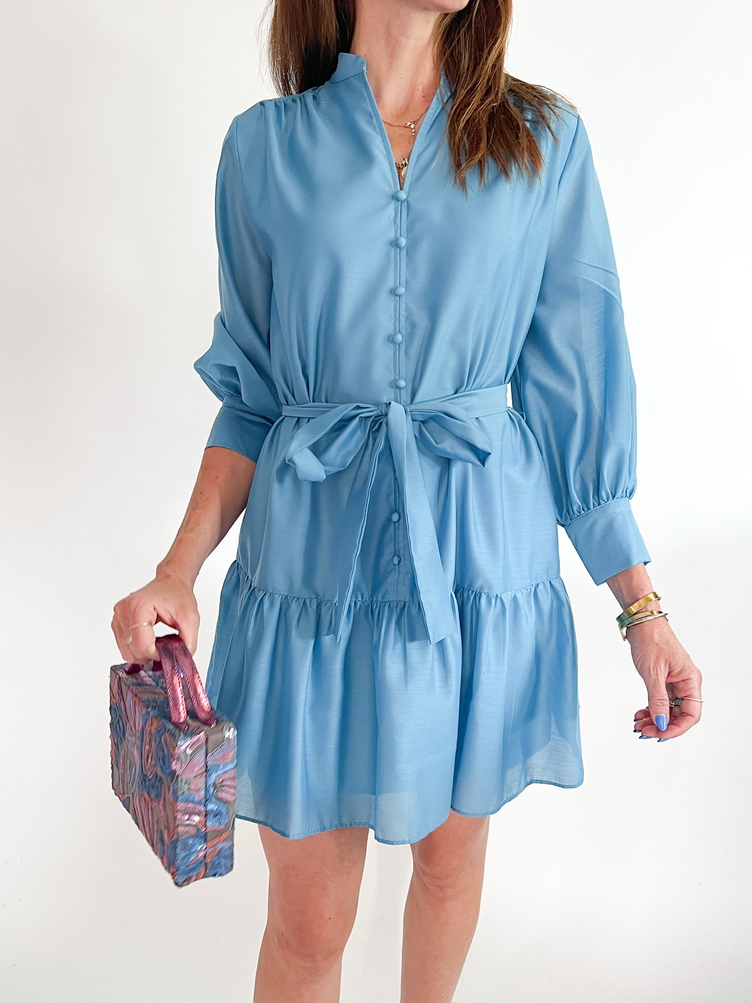 Blue tiered mini dress with long sleeves and tie waist