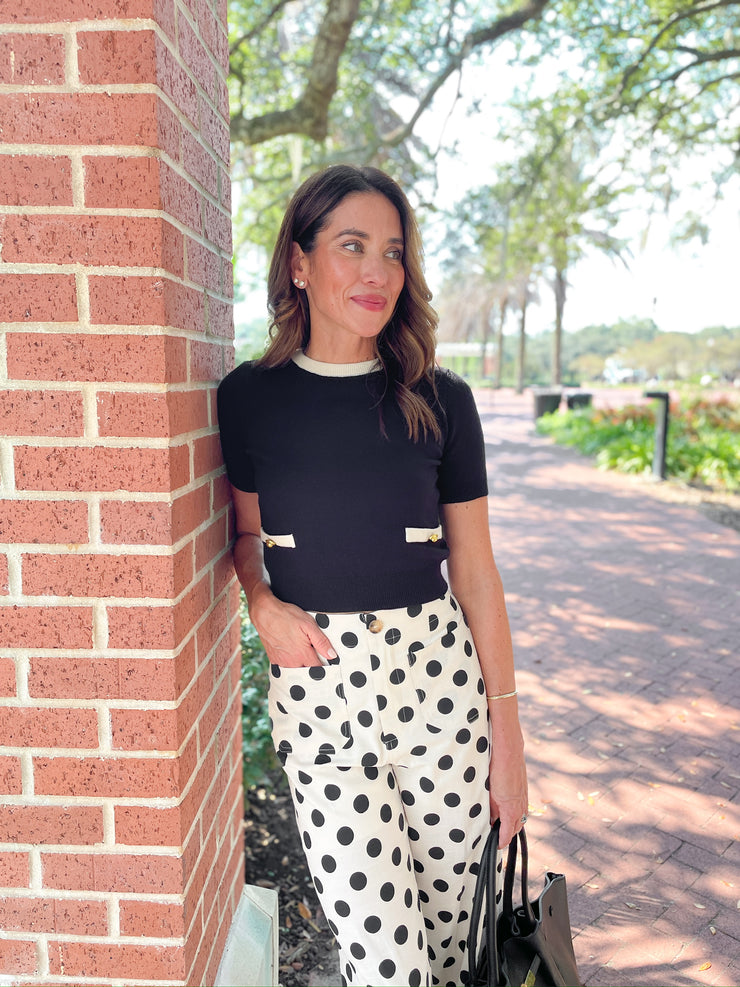 a woman leaning against a brick pillar