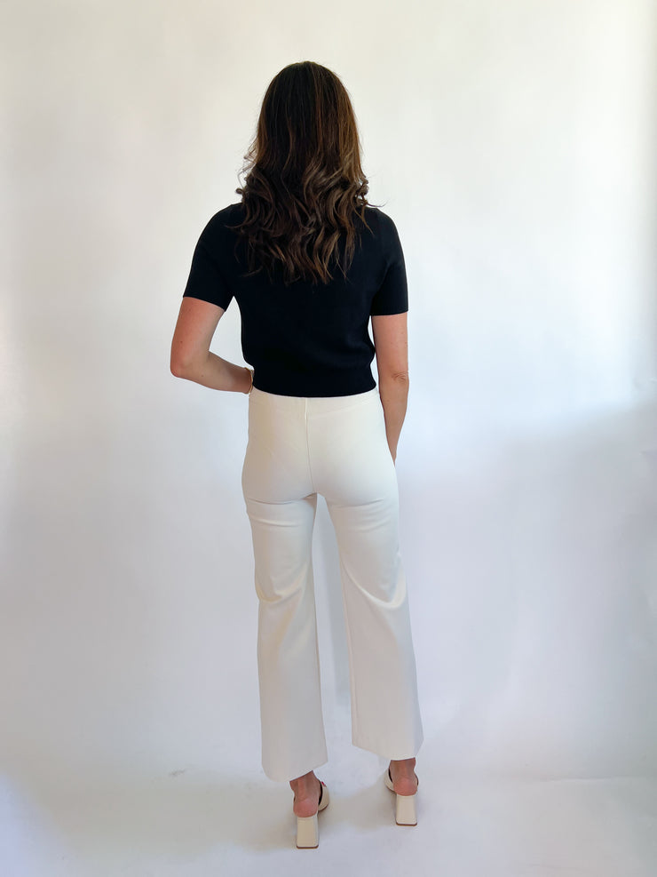 a woman in white pants and black shirt