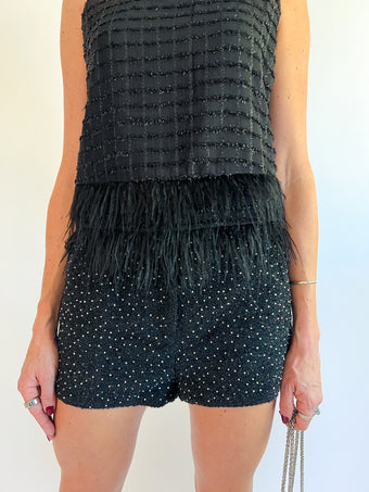 a woman wearing a black top and shorts