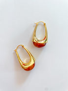 Gold teardrop hoop earrings with amber resin accent