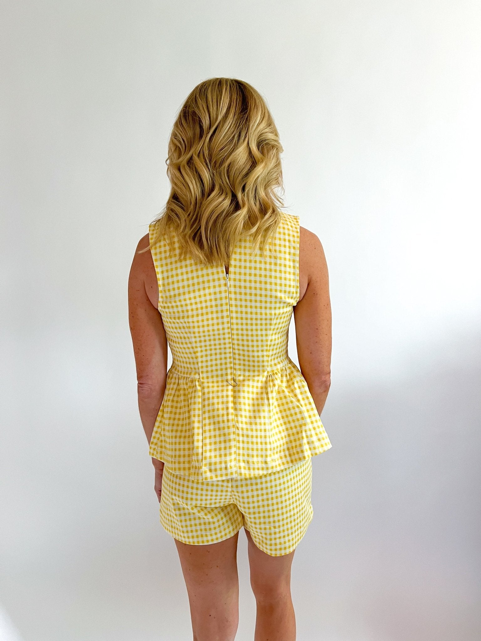 Gold gingham peplum top with structured silhouette
