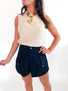 Neutral sleeveless pointelle knit top with mock neckline