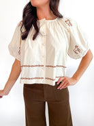 Neutral embroidered peasant top with puff sleeves