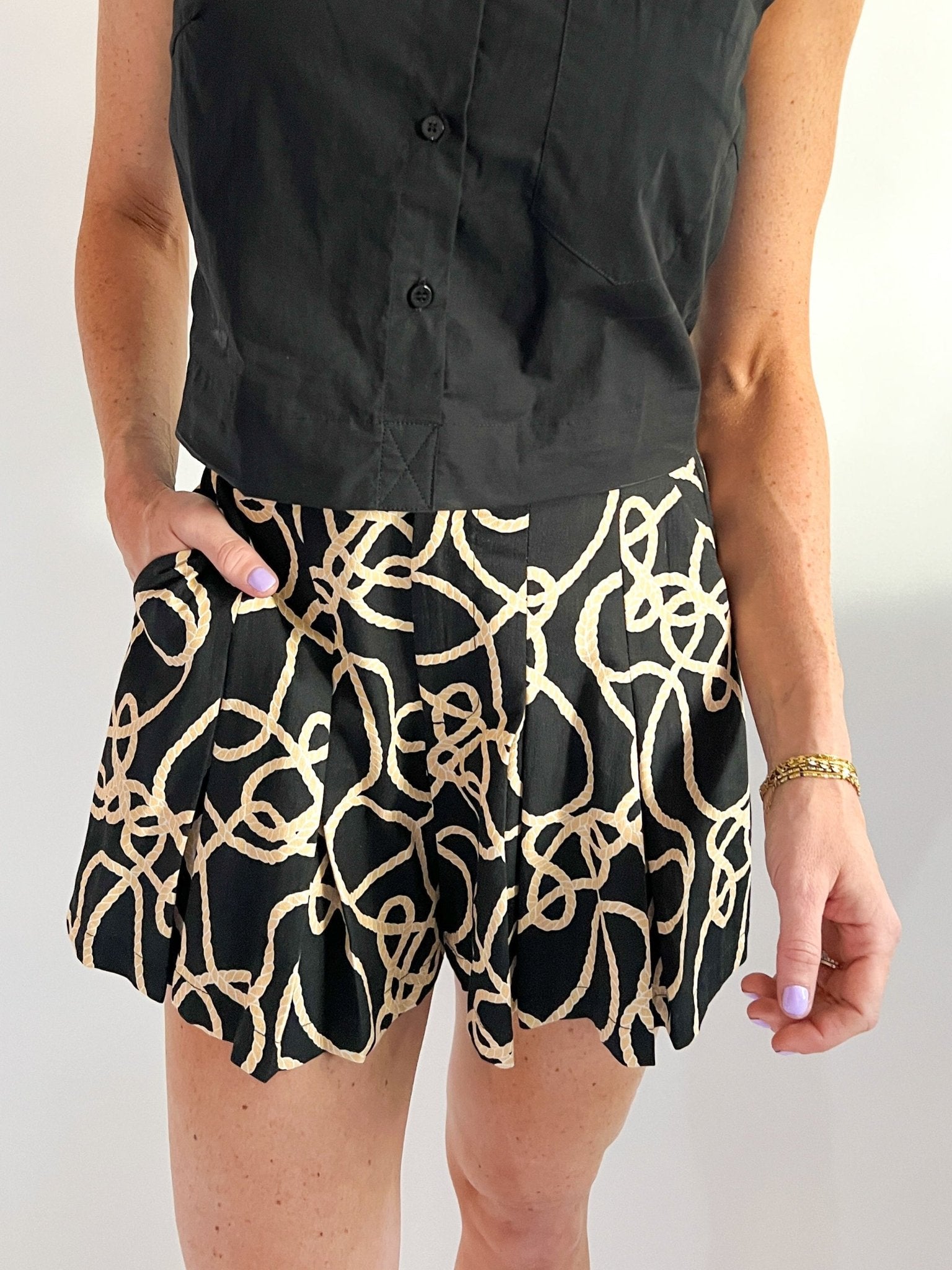 Black pleated high-waisted shorts with flared silhouette